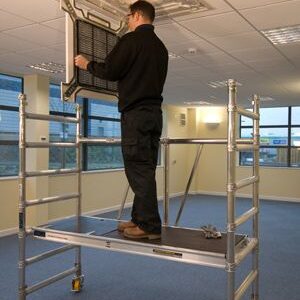 Man stood on a silver step up working on a roof fitted filter