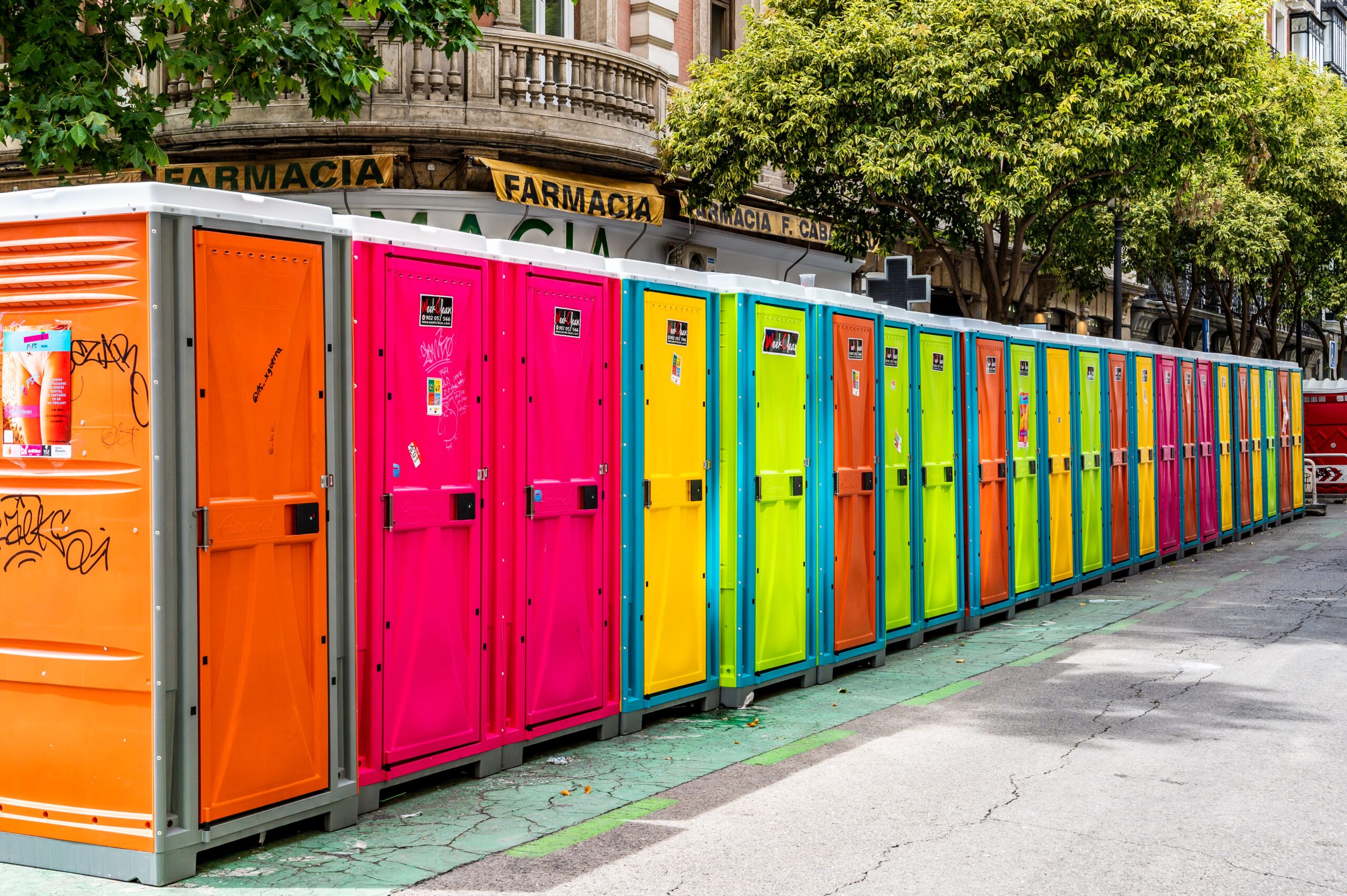 Row of vibrant brightly coloured portable toilets