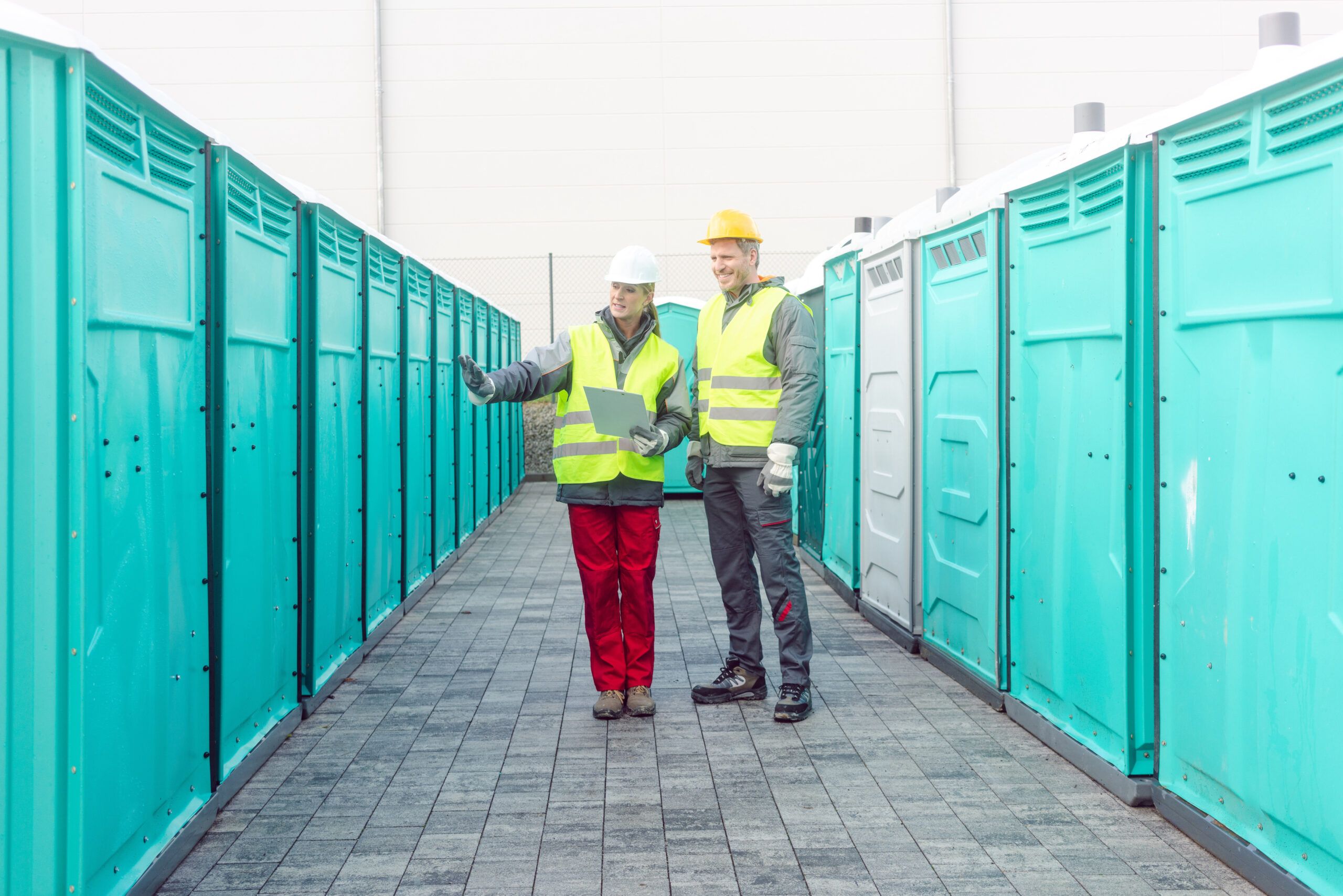 Workers Checking The Portable Toilets For Hire