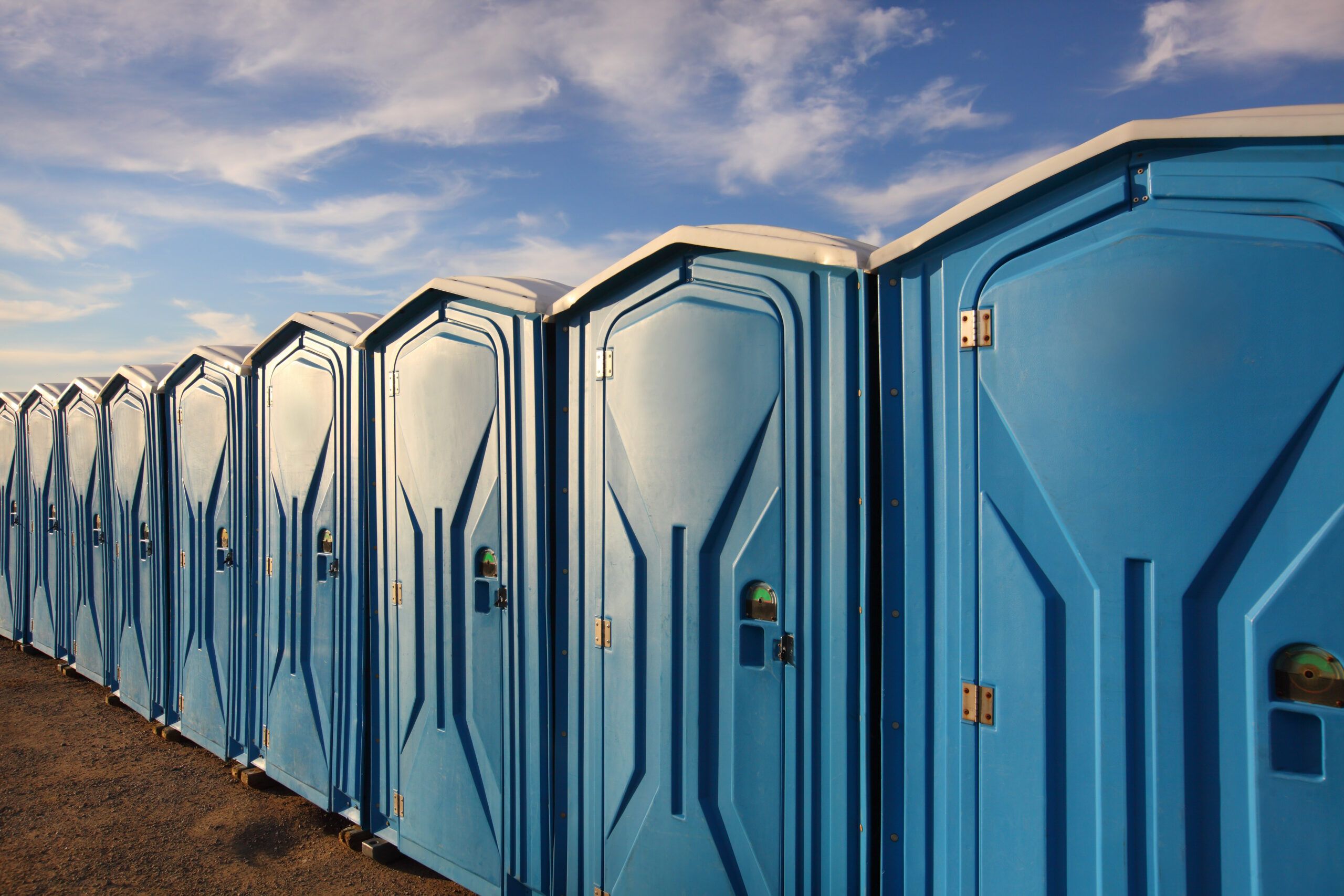 line of blue portable toilets for hire